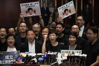 Prodemokratische Abgeordnete rufen bei einer Pressekonferenz, nachdem Regierungschefin Lam den Legislativrat verlassen hat.