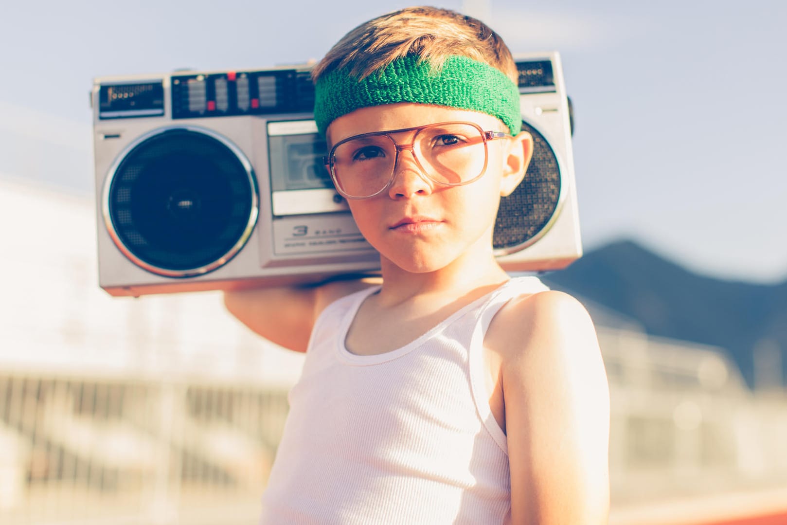 Junge mit Brille und Stirnband hört Radio