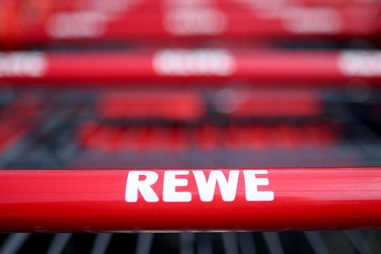 Einkaufswagen vor einem Rewe-Markt.