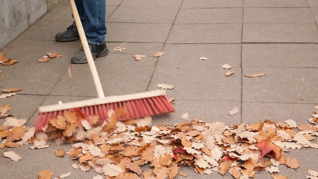 Eine Gemeinschaft von Wohnungseigentümern muss sicherstellen, dass niemand auf dem Herbstlaub ausrutschen kann.