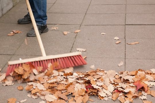 Eine Gemeinschaft von Wohnungseigentümern muss sicherstellen, dass niemand auf dem Herbstlaub ausrutschen kann.