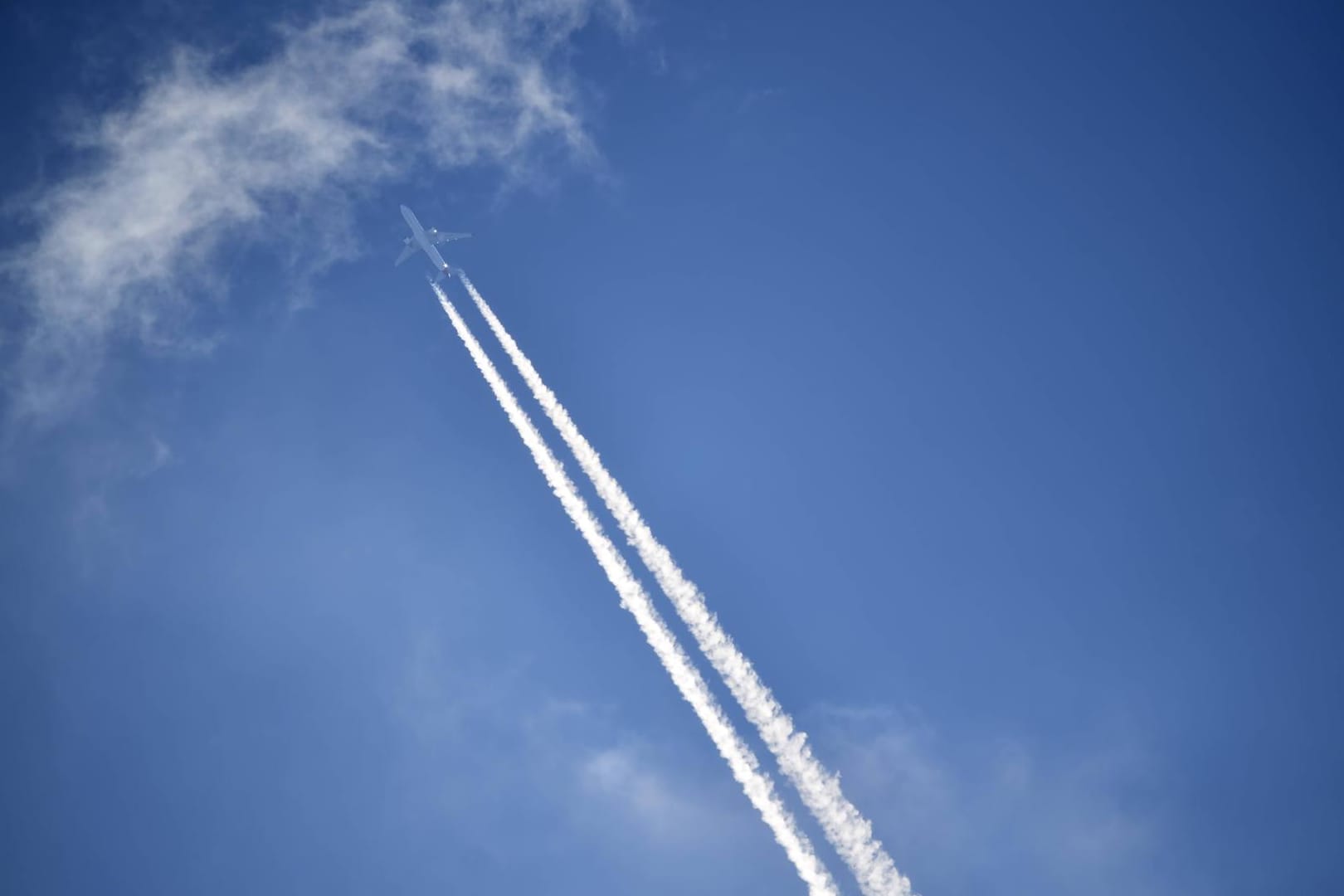 Flugzeug mit Kondensstreifen am Himmel: Künftig zahlen Verbraucher höhere Steuern auf Flugtickets. (Symbolbild)