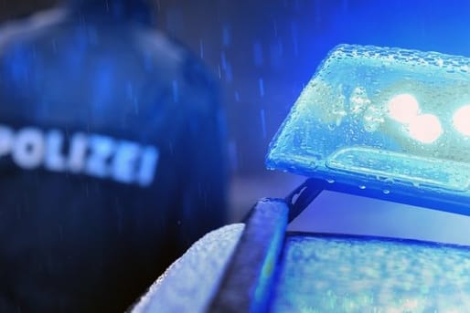 Ein Polizist hinter einem Streifenwagen: Beamte konnten auf der Autobahn bei Mainz einen 86 Jahre alten Geisterfahrer stoppen.