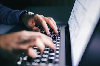 Ein Mann an einer Tastatur: Betrüger versuchen durch Tricks, an Daten oder Geld ihrer Opfer zu kommen.