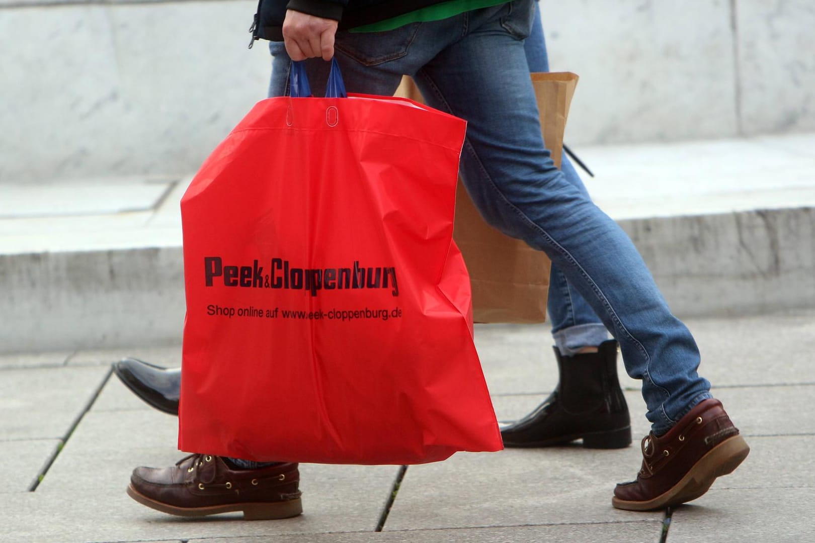Mann trägt eine Plastiktüte: Unter den wertvollsten Marken sind wenig Luxushersteller und Einzelhändler. Mann trägt eine Plastiktüte: Unter den wertvollsten Marken sind wenig Luxushersteller und Einzelhändler.