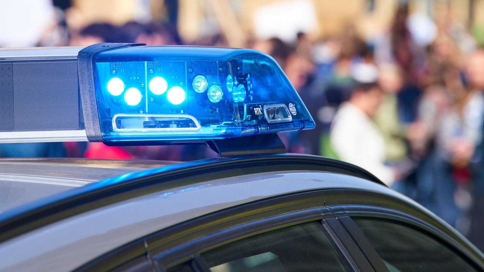 Ein Polizeiauto vor einer Menschenmenge (Symbolbild): Die Beamten in Magdeburg gaben das Einkaufszentrum nach drei Stunden wieder frei. Ein Polizeiauto vor einer Menschenmenge (Symbolbild): Die Beamten in Magdeburg gaben das Einkaufszentrum nach drei Stunden wieder frei.