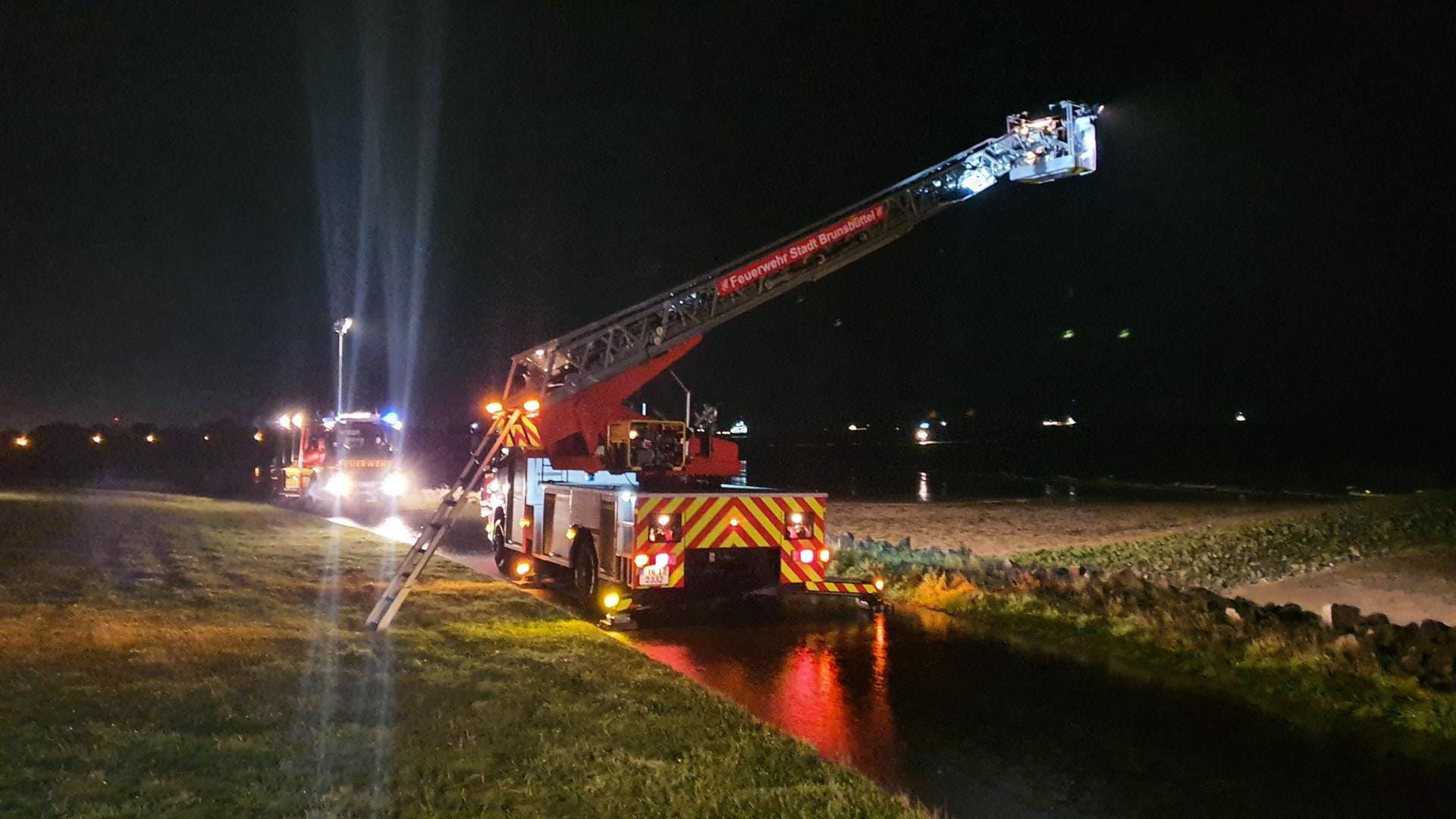 Feuerwehrfahrzeuge am Deich vor Brunsbüttel: Einsatzkräfte haben vergeblich nach einer im Watt vermissten Frau und ihrem Sohn gesucht. Ermittlungen zufolge soll sie sich mit ihrem Kind abgesetzt haben.