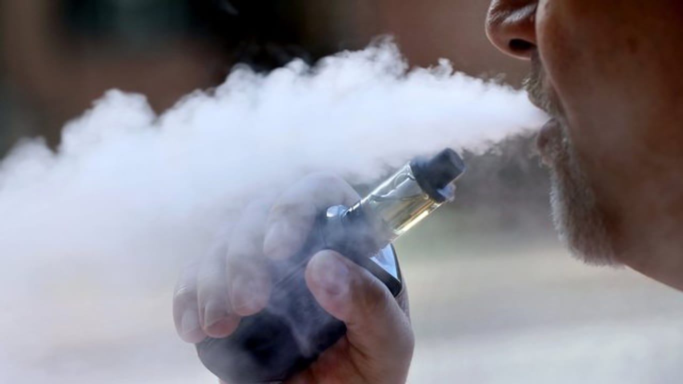 Ein Mann dampft eine E-Zigarette: Die Zahl der Nutzer von E-Zigaretten in den USA mit Lungenschäden nähert sich der Tausender-Marke. Auch die Todesfälle nehmen zu.