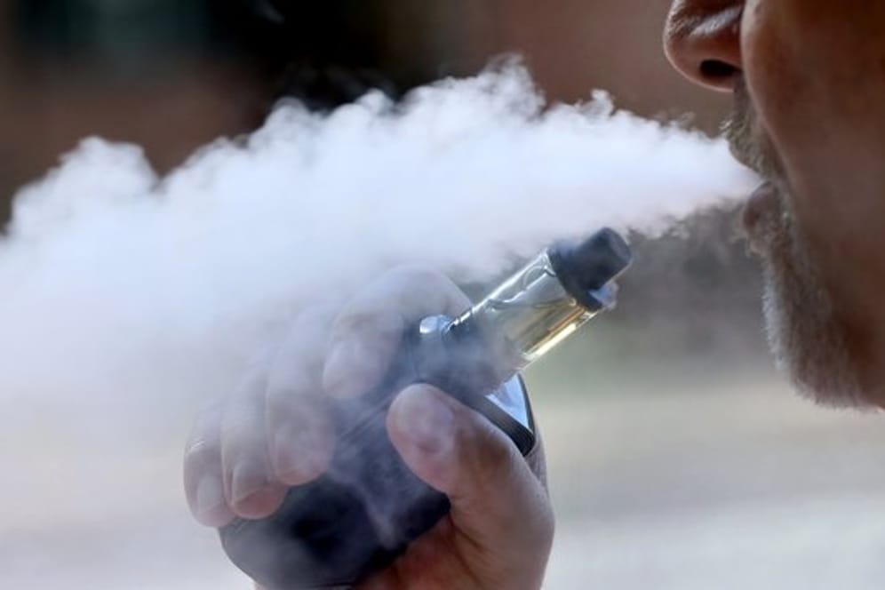 Ein Mann dampft eine E-Zigarette: Die Zahl der Nutzer von E-Zigaretten in den USA mit Lungenschäden nähert sich der Tausender-Marke. Auch die Todesfälle nehmen zu.