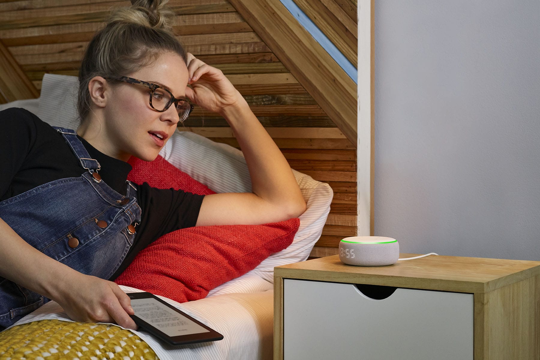 Eine junge Frau spricht im Bett mit dem neuen Echo Dot von Amazon: Die Sprachassistentin Alexa kann jetzt auch flüsternd antworten.