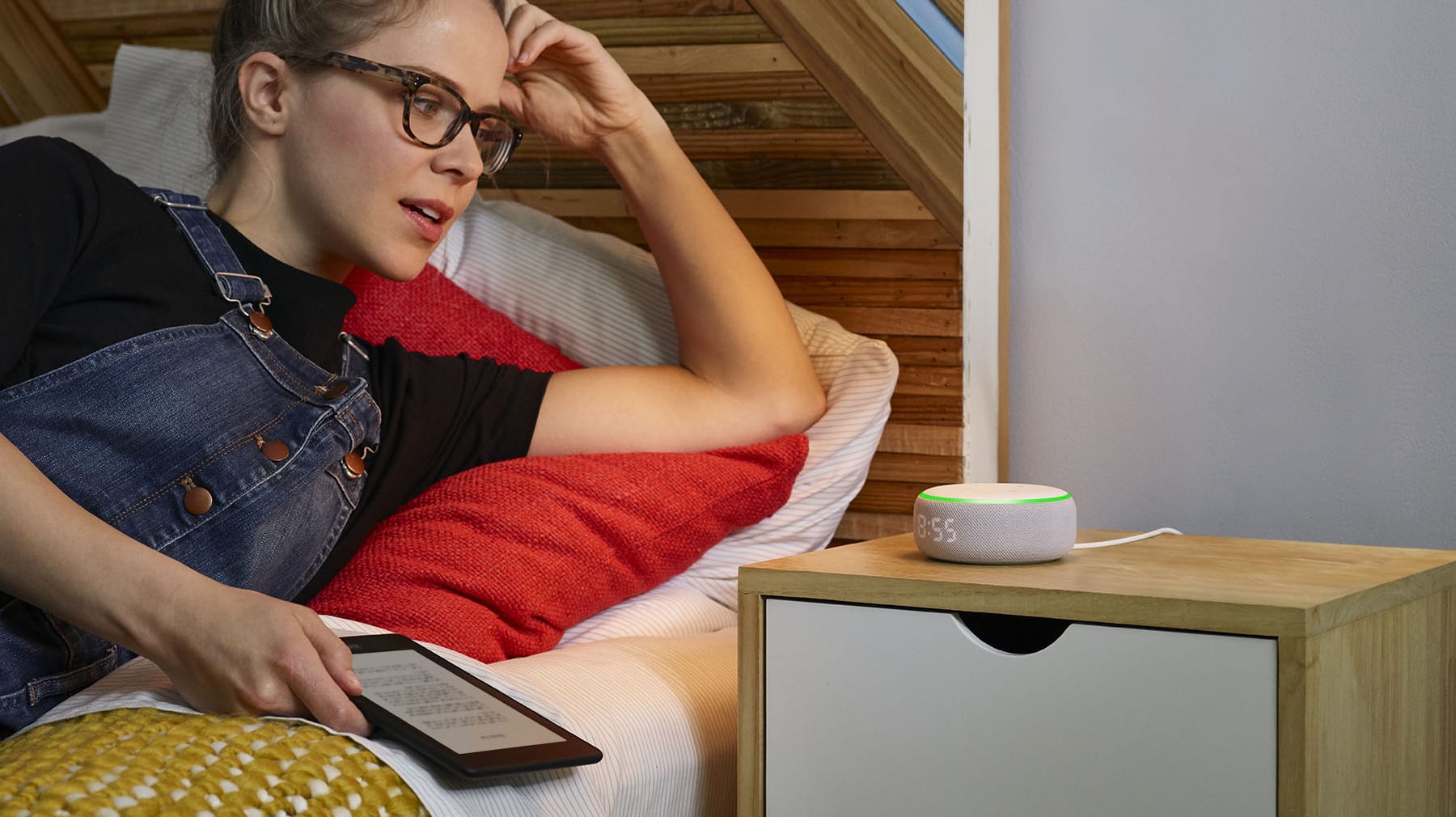 Eine junge Frau spricht im Bett mit dem neuen Echo Dot von Amazon: Die Sprachassistentin Alexa kann jetzt auch flüsternd antworten.