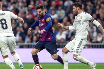 Lionel Messi (m.) im "El Clasico" gegen Toni Kroos (l.) und Sergio Ramos (r.): Das Duell zwischen dem FC Barcelona und Real Madrid ist das Highlight jeder Saison in Spanien.
