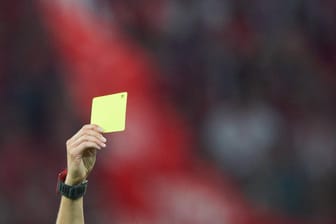 Eine gelbe Karte wird in die Luft gestreckt: Nach einer Schiedsrichter-Attacke ist der TSK Hohenlimburg mit langen Sperren bestraft worden.