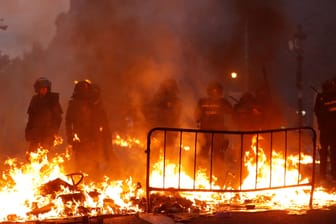 Polizisten an einer brennenden Blockade: Proteste in Barcelona sind eskaliert.