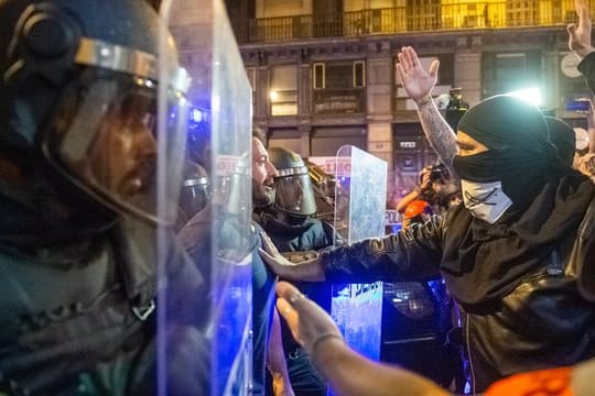 In der Innenstadt von Barcelona stehen sich Demonstranten und Polizisten gegenüber.
