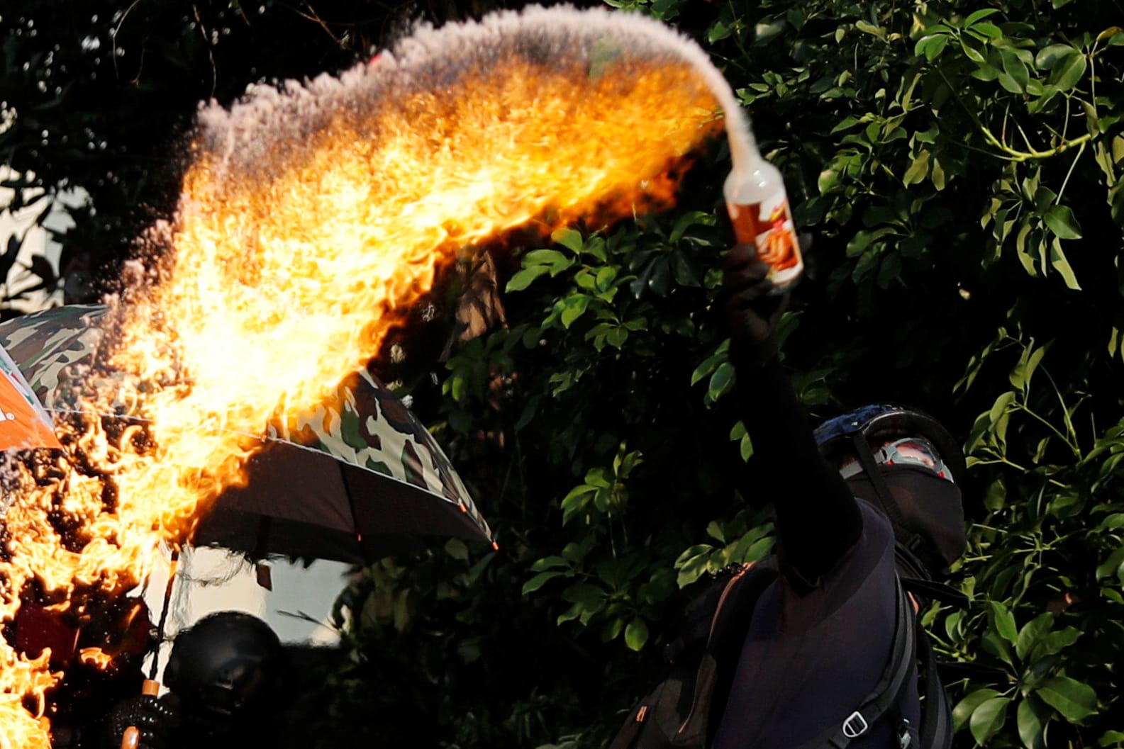 Demonstrant schleudert eine Benzinbombe: Die Polizei hält mit Wasserwerfern und Tränengas dagegen.