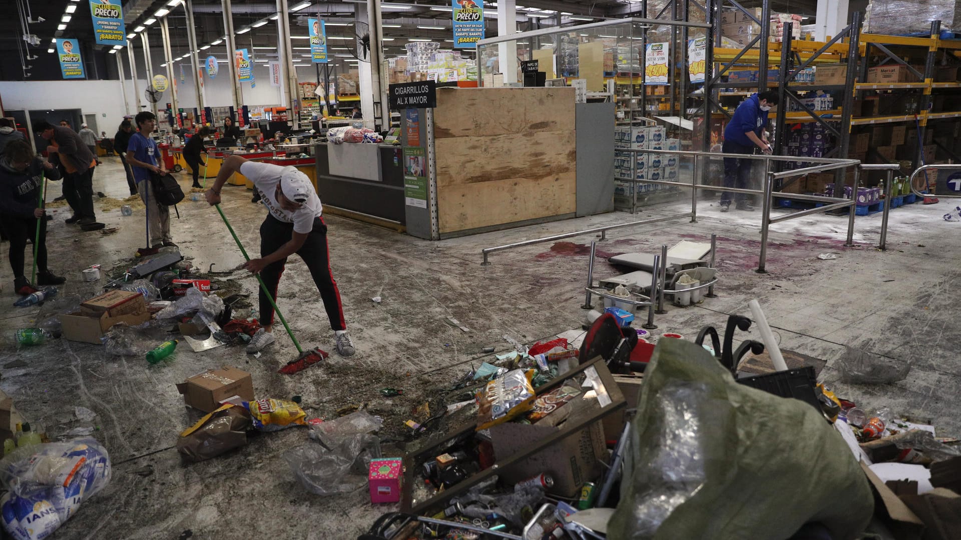 Aufräumen nach der Feuerkatastrophe: In diesem Supermarkt in Santiago de Chile starben drei Menschen; der Markt geriet bei einer Plünderung in Brand.