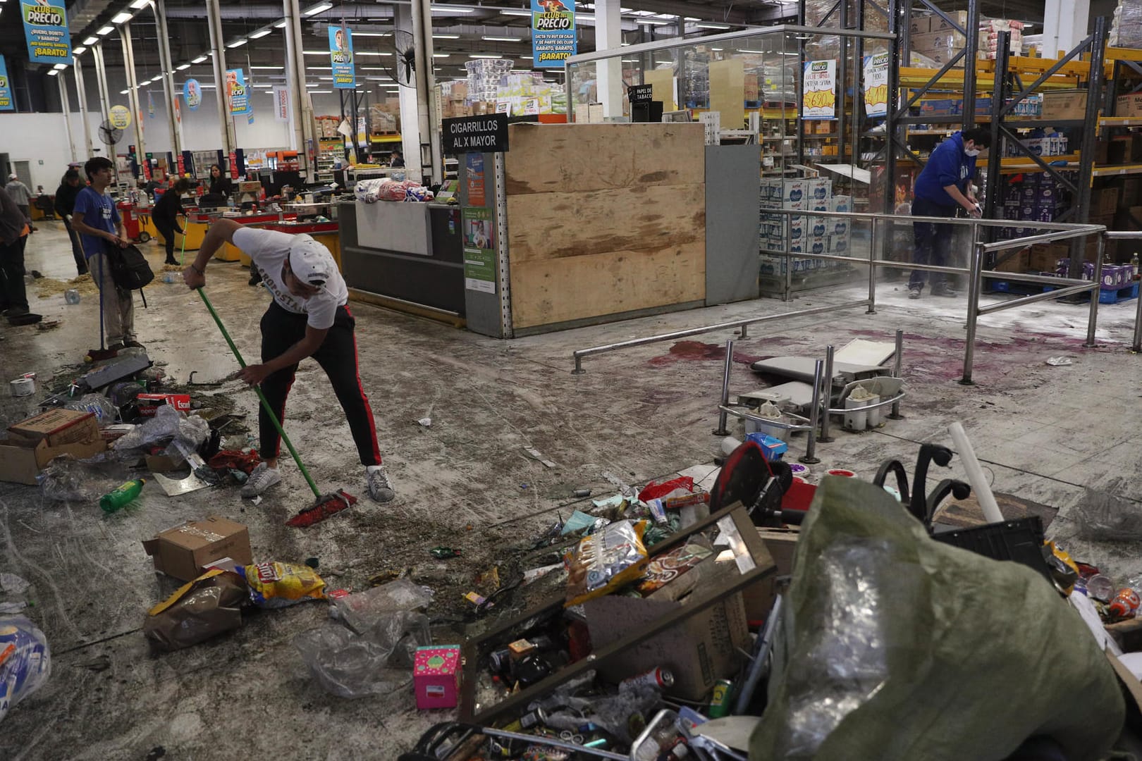 Aufräumen nach der Feuerkatastrophe: In diesem Supermarkt in Santiago de Chile starben drei Menschen; der Markt geriet bei einer Plünderung in Brand.