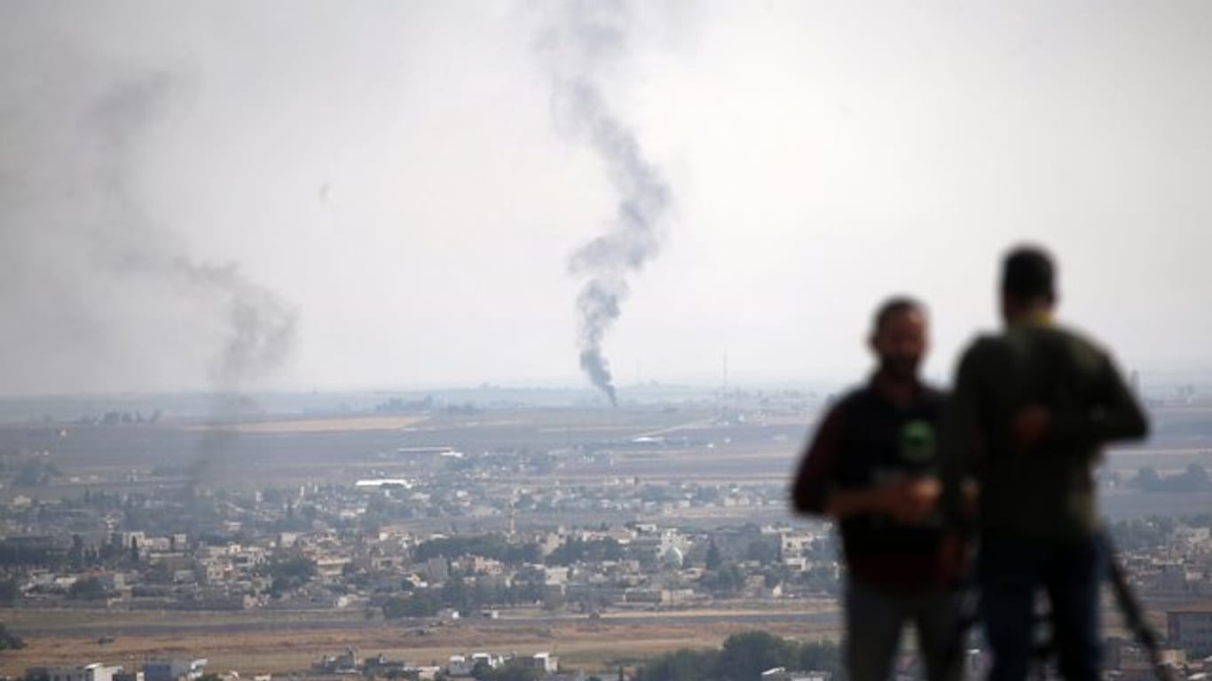 TV-Journalisten beobachten von einer Anhöhe auf der türkischen Seite der Grenze aus Rauch über dem nordsyrischen Ras al-Ayn.