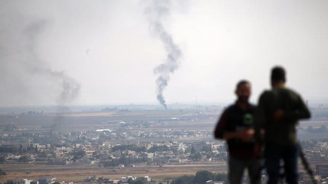 TV-Journalisten beobachten von einer Anhöhe auf der türkischen Seite der Grenze aus Rauch über dem nordsyrischen Ras al-Ayn. TV-Journalisten beobachten von einer Anhöhe auf der türkischen Seite der Grenze aus Rauch über dem nordsyrischen Ras al-Ayn.