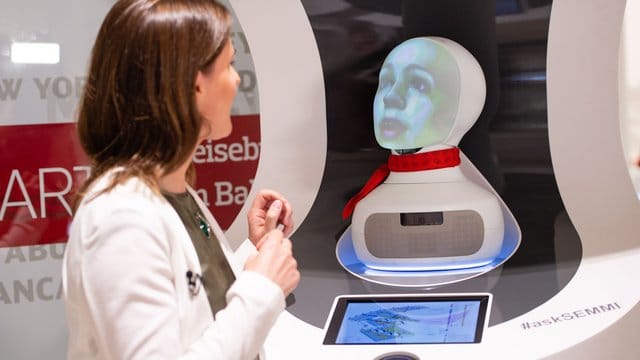 Eine Frau spricht im Reisenzetrum des Hauptbahnhofs mit "Semmi", einem Roboter vom Kundenservice der Deutsche Bahn, der auf Basis Künstlicher Intelligenz (KI) funktioniert. Eine Frau spricht im Reisenzetrum des Hauptbahnhofs mit "Semmi", einem Roboter vom Kundenservice der Deutsche Bahn, der auf Basis Künstlicher Intelligenz (KI) funktioniert.