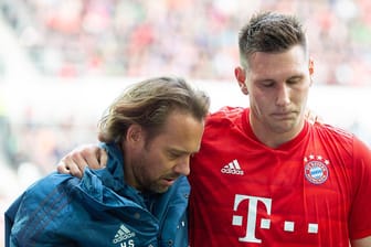 Niklas Süle wird beim Spiel in Augsburg verletzt vom Platz geführt: Der Nationalspieler fällt mit einem Kreuzbandriss lange aus.