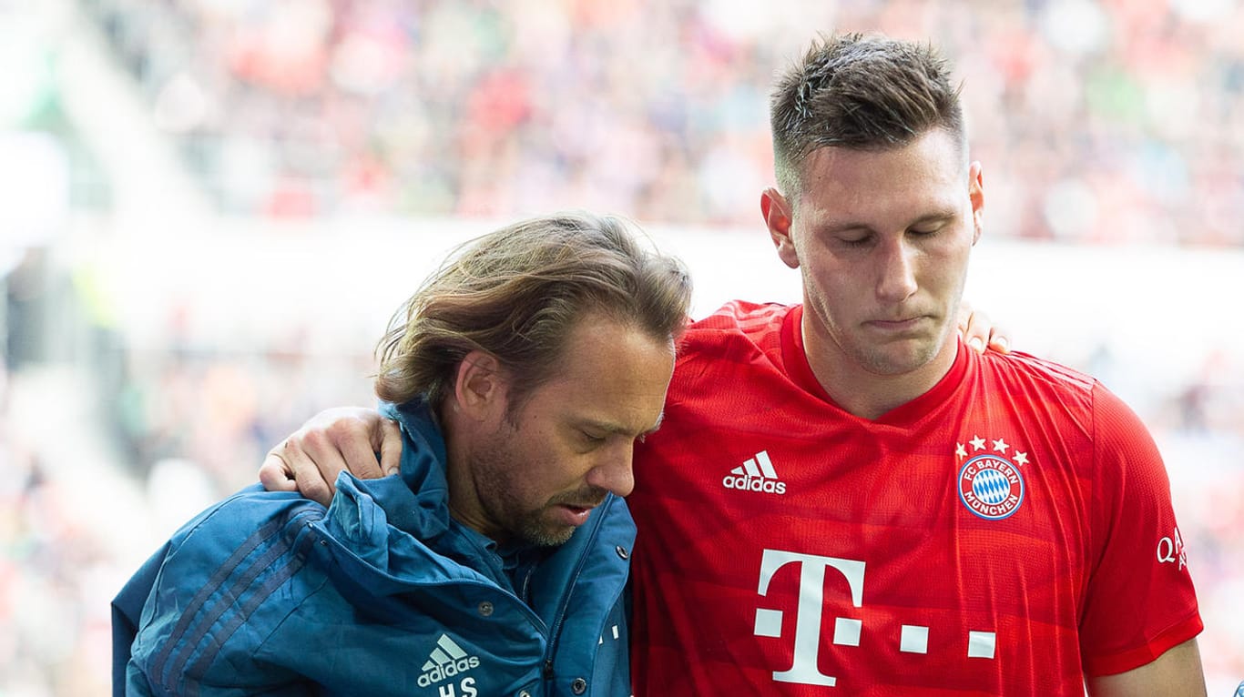 Niklas Süle wird beim Spiel in Augsburg verletzt vom Platz geführt: Der Nationalspieler fällt mit einem Kreuzbandriss lange aus.