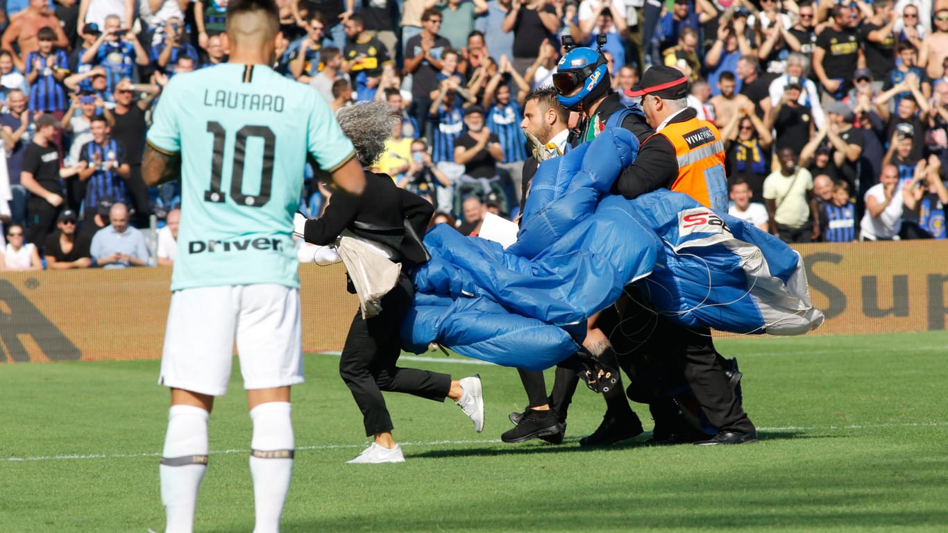 Fallschirmspringer wird abgeführt: Während des Serie A-Spiels zwischen Sassuolo und Inter Mailand landete ein Fallschirmspringer auf dem Platz.