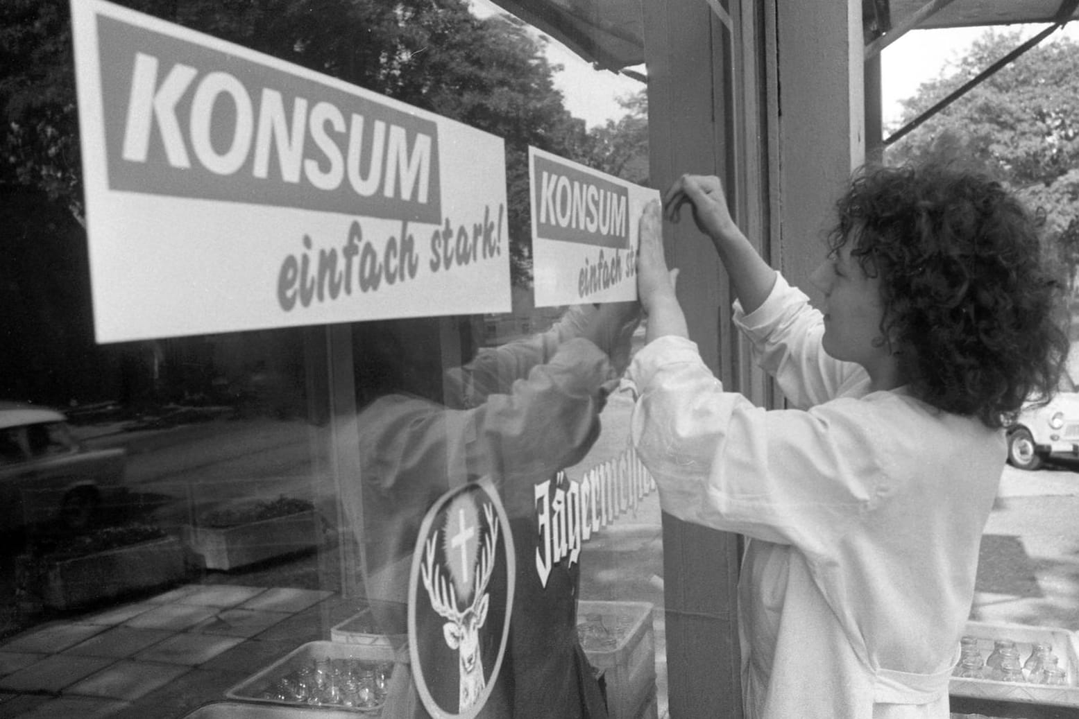 Kurz vor der Währungsunion bringt eine Verkäuferin in Leipzig ein neues Konsum-Logo an (Archivbild): Die Handelsgenossenschaft will nun kräftig expandieren.