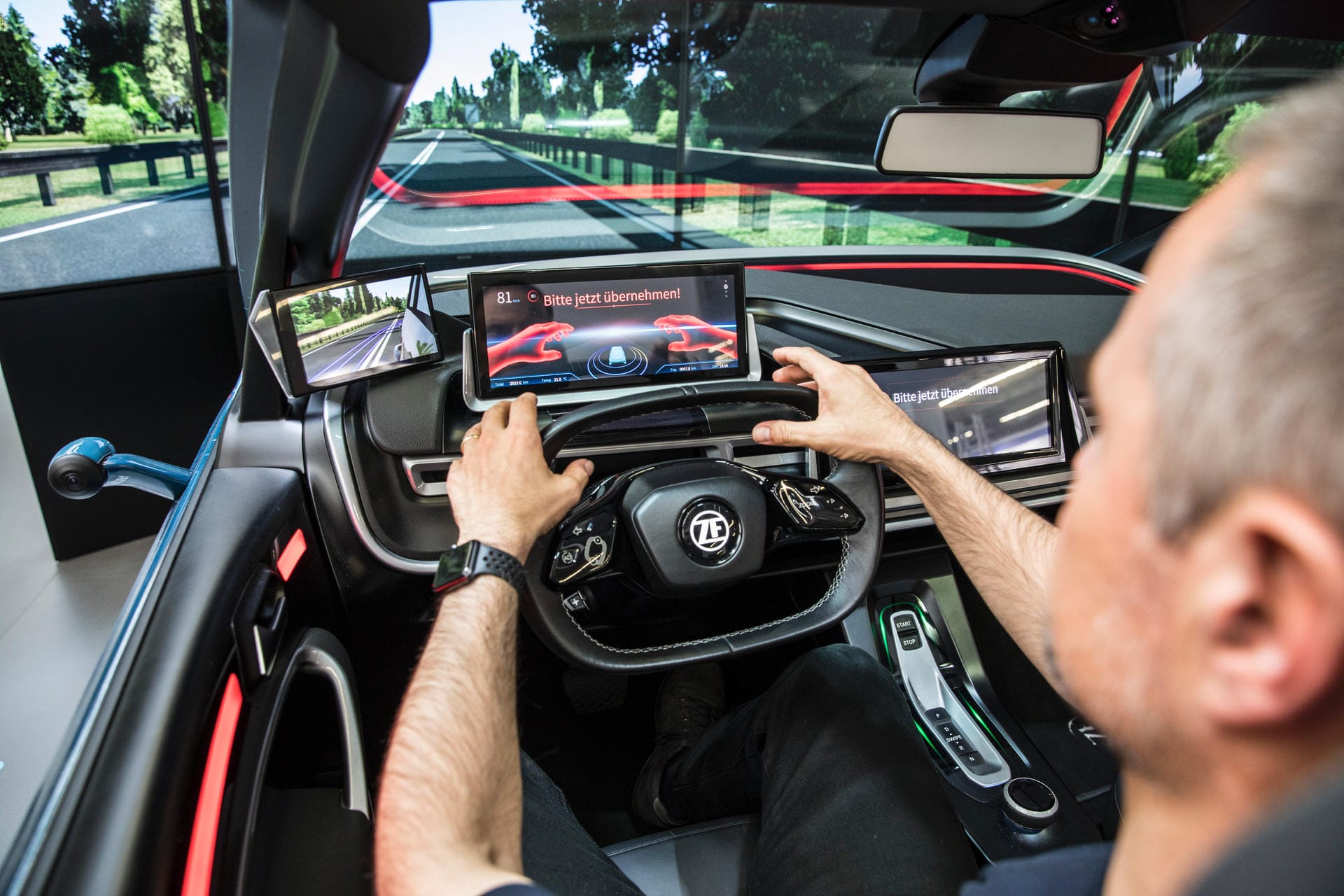 Ein Mann fährt ein Auto: Menschliche und elektronische Fahrzeuglenker werden bei ZF miteinander kombiniert.