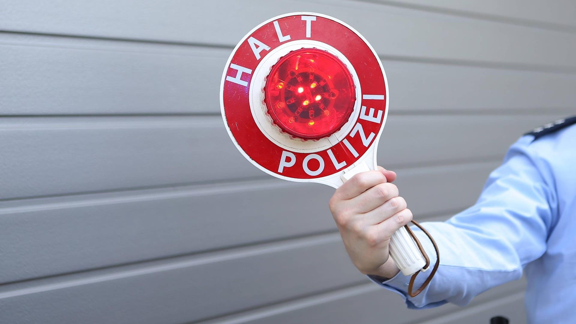 Ein Polizist mit einer Kelle: Nachdem die Beamten den Mann bei dem Schilderwechsel beobachtet hatten, kontrollierten sie sein Fahrzeug. (Symbolbild) Ein Polizist mit einer Kelle: Nachdem die Beamten den Mann bei dem Schilderwechsel beobachtet hatten, kontrollierten sie sein Fahrzeug. (Symbolbild)