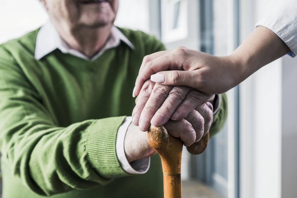 Frau hält die Hand eines Senioren: In bestimmten Fällen können Krankenkassen die Zahlung an den Pflegedienst ablehnen.
