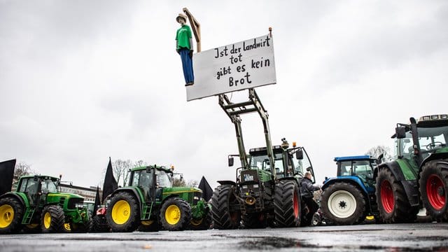 Eine Puppe hängt an einem Traktor und baumelt an einem Galgen mit dem Schild: "Ist der Landwirt tot gibt es kein Brot". Eine Puppe hängt an einem Traktor und baumelt an einem Galgen mit dem Schild: "Ist der Landwirt tot gibt es kein Brot".