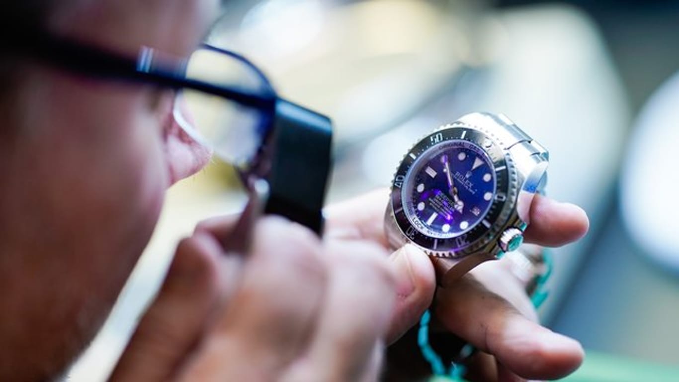 Bernd Barz, Filialleiter des „City Leihhaus“, überprüft im Pfandleihhaus mit einer Lupe eine Uhr der Marke „Rolex“.