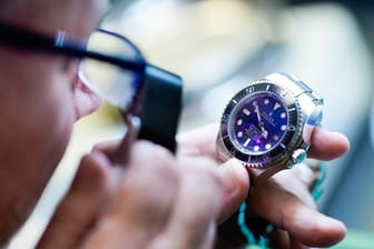 Bernd Barz, Filialleiter des „City Leihhaus“, überprüft im Pfandleihhaus mit einer Lupe eine Uhr der Marke „Rolex“.
