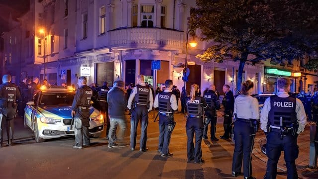Polizisten stehen am Abend in der Innenstadt von Herne.