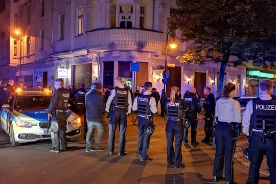Polizisten stehen am Abend in der Innenstadt von Herne.