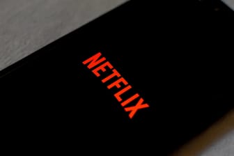 Das Logo von Netflix auf einem Smartphone: Der Streamingdienst will gegen das Teilen von Passwörtern vorgehen.