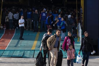 Flüchtlinge verlassen eine Fähre: Die griechische Regierung verlegt derzeit hunderte Migranten aufs Festland.