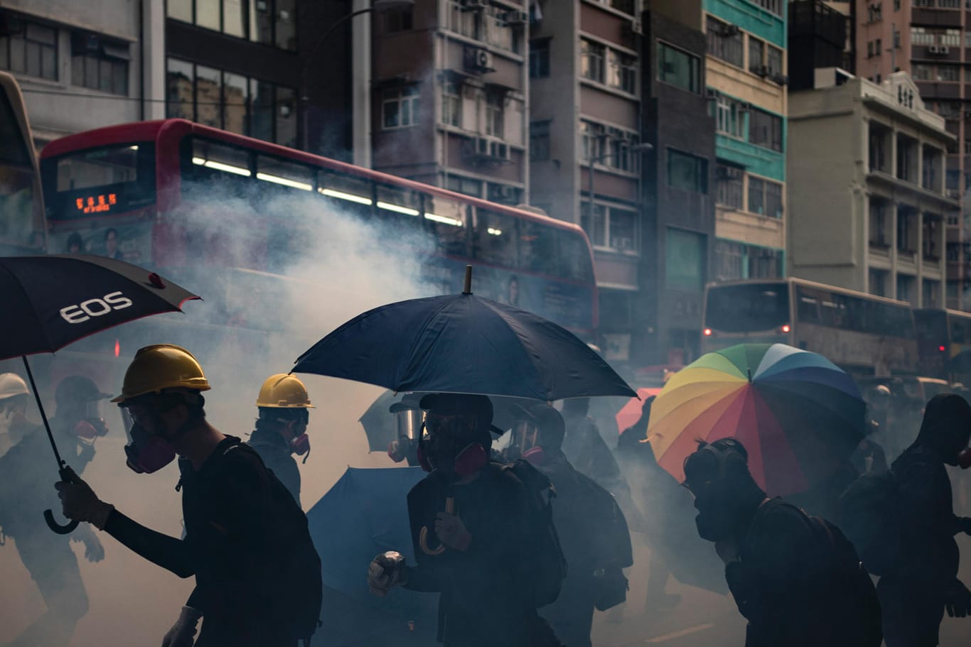 Demonstranten schützen sich mit Regenschirmen und Atemschutzmasken gegen das Tränengas der Polizei: Die Regierung geht hart gegen die Proteste vor.