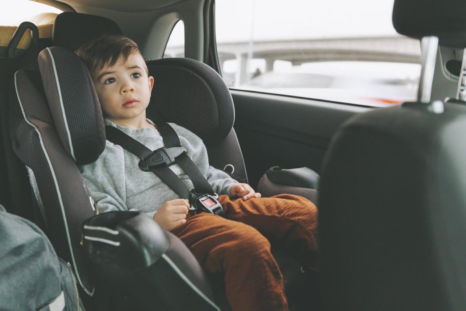 Junge auf Kindersitz: Kinder bis zu einer Körpergröße von 150 Zentimetern müssen im Auto in geeigneten Kindersitzen geschützt werden.