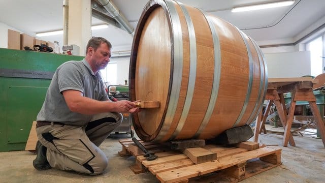 Der Böttcher Carsten Romberg mit letzten Handgriffen an einem Fass in seiner Werkstatt in Roßbach bei Naumburg.