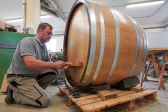 Der Böttcher Carsten Romberg mit letzten Handgriffen an einem Fass in seiner Werkstatt in Roßbach bei Naumburg.