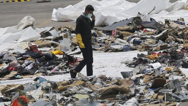 Ein Ermittler inmitten von Trümmern der Boeing 737 Max von Lion Air. Ein Ermittler inmitten von Trümmern der Boeing 737 Max von Lion Air.