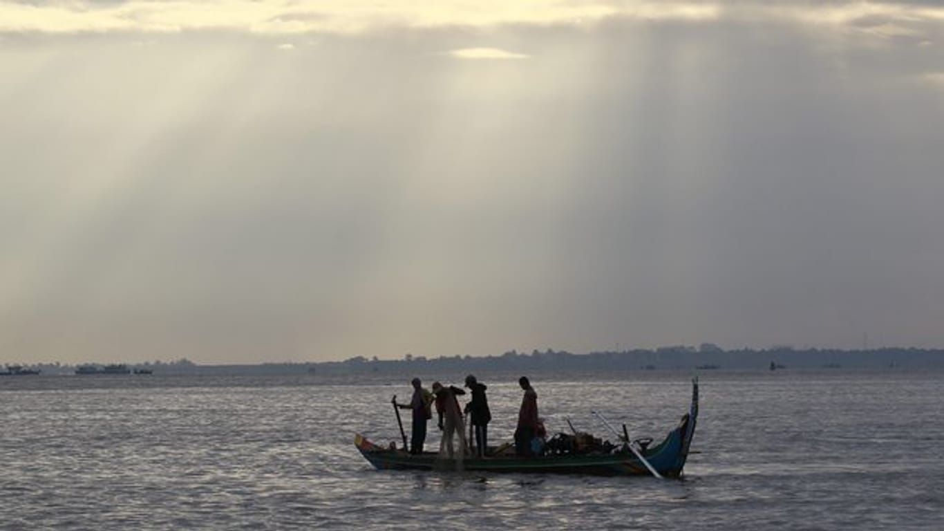 Kambodschanische Fischer fahren auf dem Mekong-Fluss in Phnom Penh mit ihrem Boot.