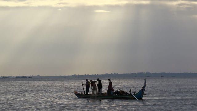Kambodschanische Fischer fahren auf dem Mekong-Fluss in Phnom Penh mit ihrem Boot. Kambodschanische Fischer fahren auf dem Mekong-Fluss in Phnom Penh mit ihrem Boot.