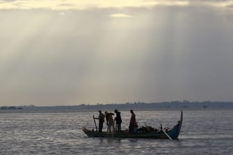 Kambodschanische Fischer fahren auf dem Mekong-Fluss in Phnom Penh mit ihrem Boot.