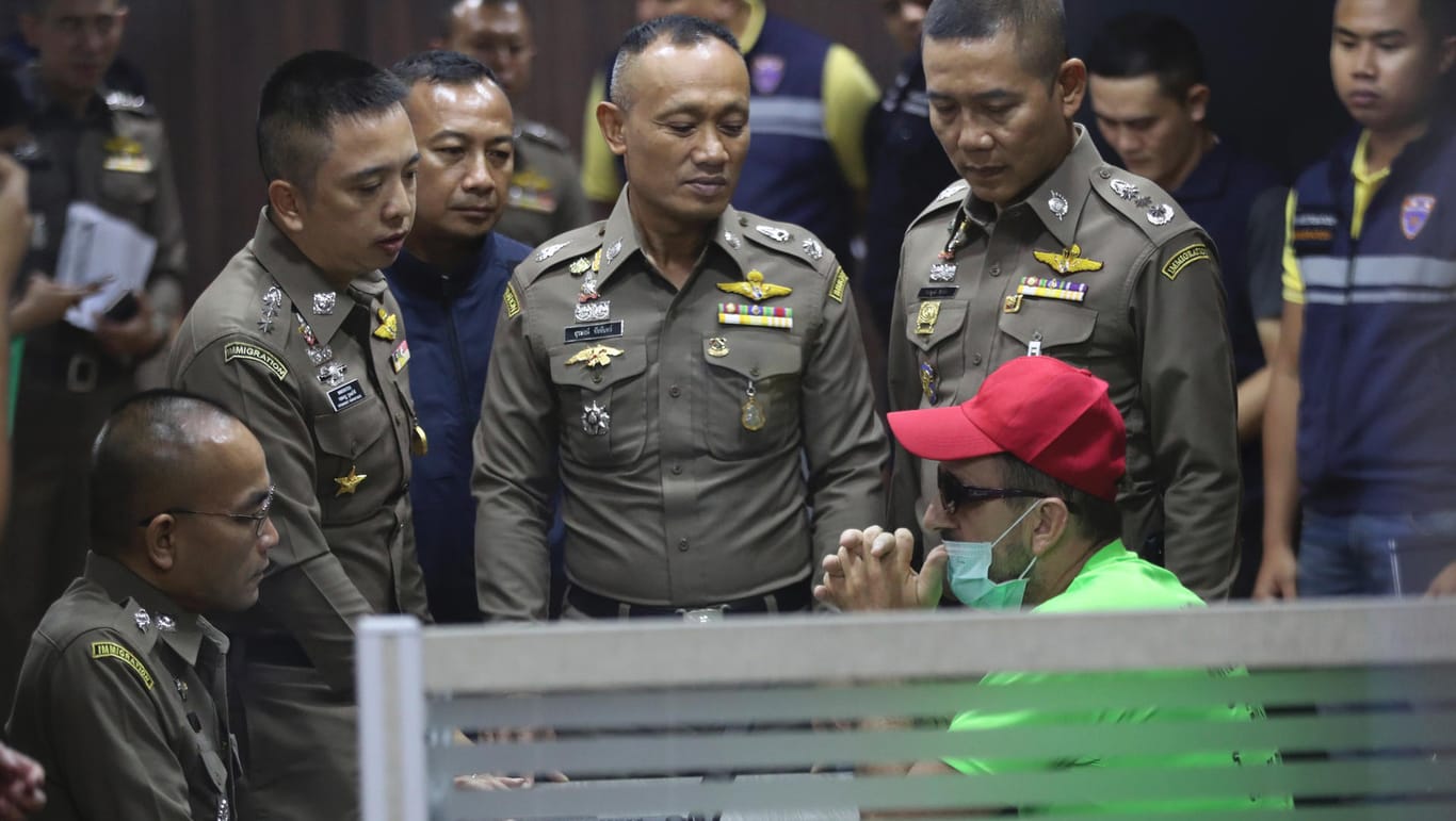 Der Hauptverdächtige spricht mit Beamten der thailändischen Einwanderungsbehörde: Der 52-Jährige darf das Gefängnis nicht verlassen.