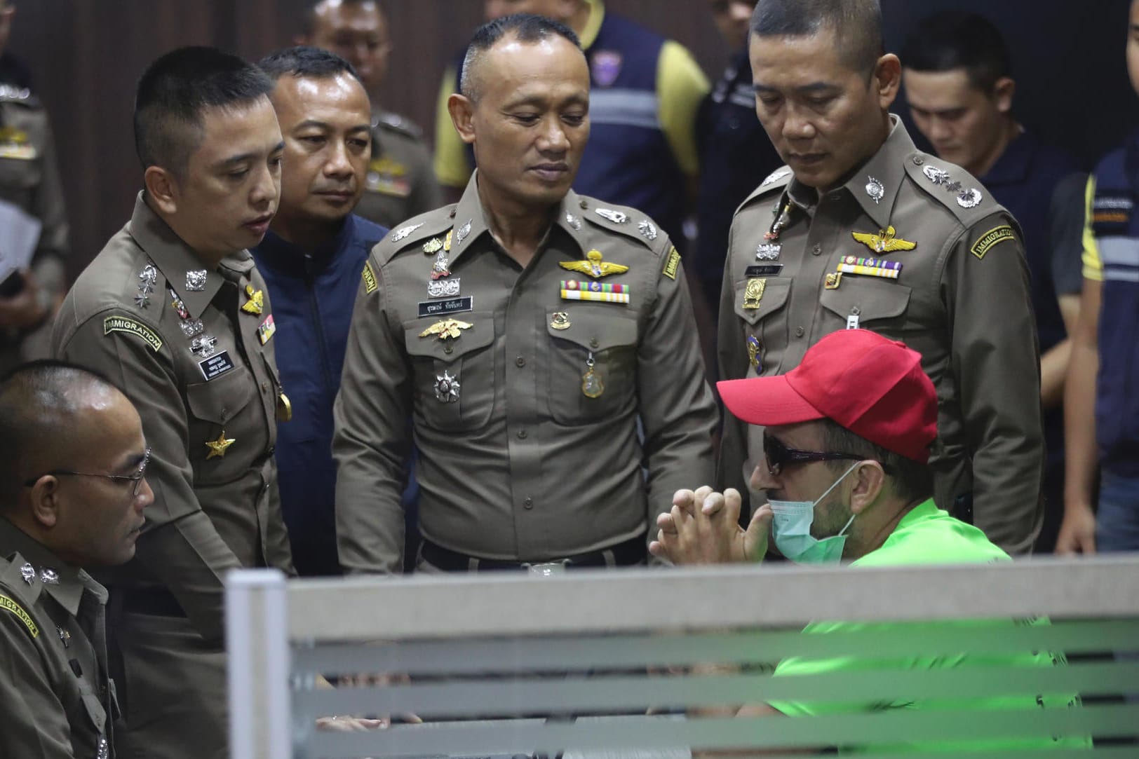 Der Hauptverdächtige spricht mit Beamten der thailändischen Einwanderungsbehörde: Der 52-Jährige darf das Gefängnis nicht verlassen.
