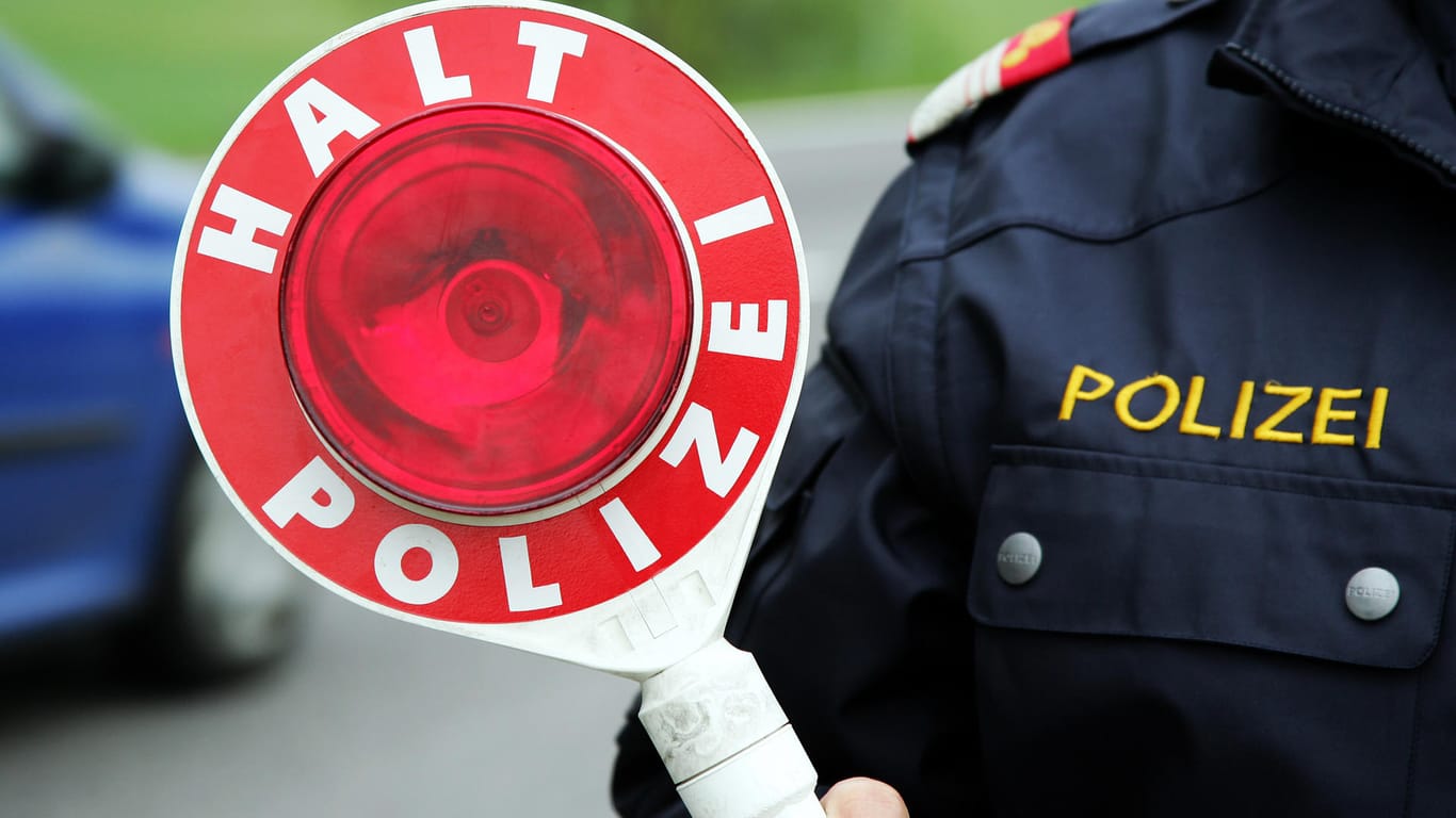 Ein Polizist hält eine Kelle: In Mainz riefen mehrere Zeugen die Polizei, weil sie einen verdächtigen Autofahrer bemerkten.